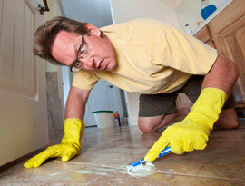 man scrubbing tile and grout